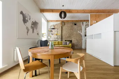 a kitchen and dining room with a wooden table and chairs at Cozy studio apartment central in Vilnius