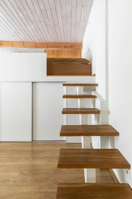 a staircase in a house with a wooden ceiling at Cozy studio apartment central in Vilnius