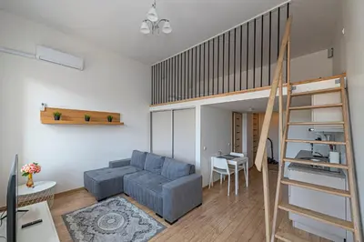 a living room with a couch and a loft bed at New Town loft apartment with air conditioning by Polo Apartments in Kaunas