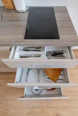 a kitchen counter with a drawer with utensils at New Town loft apartment with air conditioning by Polo Apartments in Kaunas