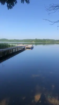 a large body of water with a dock at Šeimos Namelis Adomo Sodyboje prie ežero 35 km nuo Vilniaus šalia Dubingių in Dirmeičiai