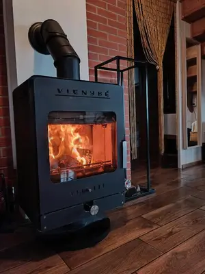 a stove with a fire inside of a room at Arimaičių kaimo sodyba in Arimaičiai