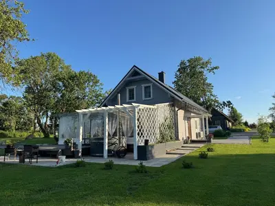 a house with a screened in porch in a yard at Arimaičių kaimo sodyba in Arimaičiai