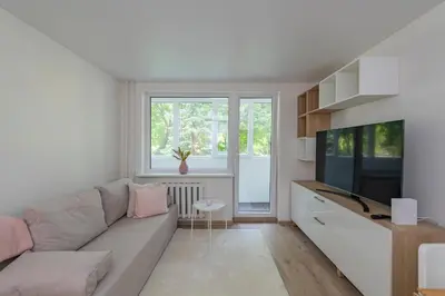 a living room with a couch and a television at Convenient apartment with balcony by Polo Apartments in Kaunas