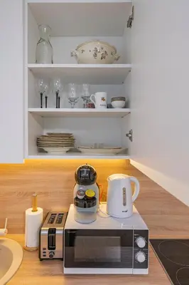 a kitchen with a microwave and a coffee maker on a counter at Convenient apartment with balcony by Polo Apartments in Kaunas