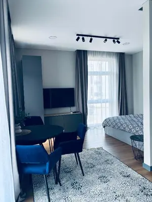 a living room with a table and chairs and a bedroom at Ainių gatvės apartamentai in Panevėžys