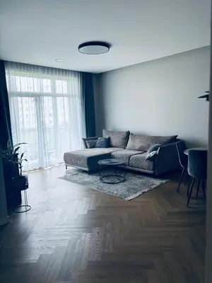 a living room with a couch and a table at Ainių gatvės apartamentai in Panevėžys