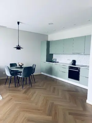a kitchen with a table and chairs in a room at Ainių gatvės apartamentai in Panevėžys
