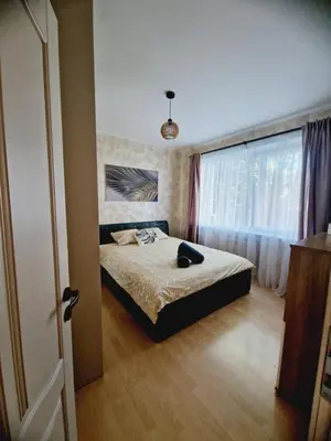 a bedroom with a bed and a large window at Apartamentai Sukileliu pr. in Kaunas