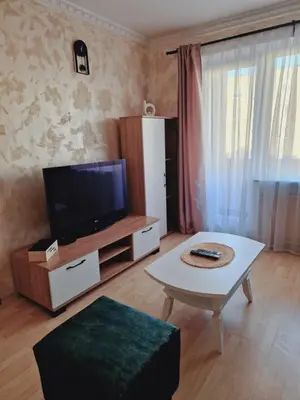 a living room with a tv and a coffee table at Apartamentai Sukileliu pr. in Kaunas