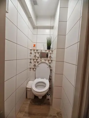 a bathroom with a white toilet in a room at Apartamentai Sukileliu pr. in Kaunas