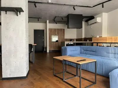 a living room with a blue couch and a table at Carlo Apartments in Birštonas