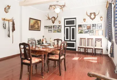 a dining room with a wooden table and chairs at Skiemonių Dvaras in Skiemonys