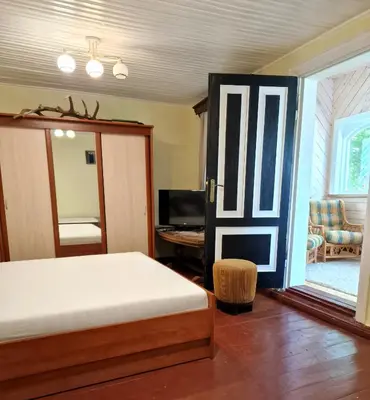 a bedroom with a bed and a sliding glass door at Skiemonių Dvaras in Skiemonys