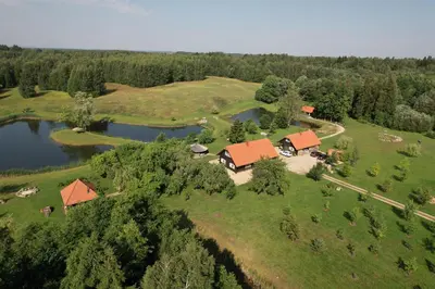 an aerial view of a farm with a house and a lake at Anykščiai MĖNULIO AKMUO in Kavoliškis