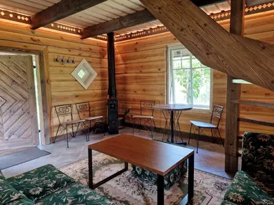 a room with a table and chairs in a cabin at Anykščiai MĖNULIO AKMUO in Kavoliškis