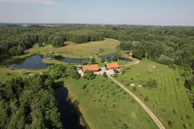 an aerial view of a house on a farm next to a river at Anykščiai MĖNULIO AKMUO in Kavoliškis