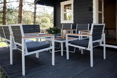 a group of chairs and a table on a porch at Spyglyne in Braziūkai