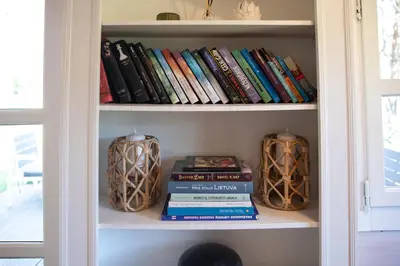 a book shelf filled with books and vases at Spyglyne in Braziūkai