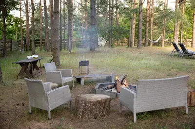 a group of chairs and a fire pit in a yard at Spyglyne in Braziūkai