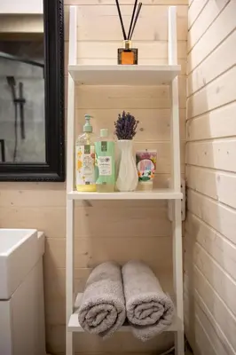 a bathroom with a sink and towels on a shelf at Spyglyne in Braziūkai