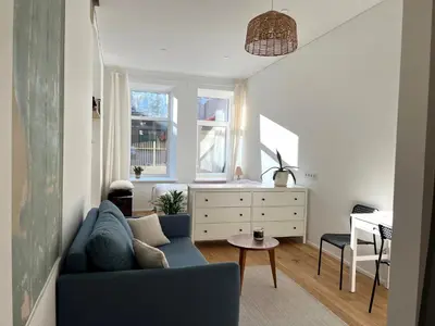 a living room with a blue couch and a table at Cozy studio in Sv Stepono g. in Vilnius