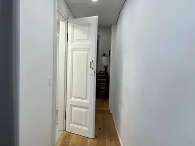 a hallway with a white door and a white wall at Cozy studio in Sv Stepono g. in Vilnius