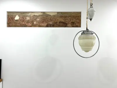a light fixture hanging on a white wall at Cozy studio in Sv Stepono g. in Vilnius
