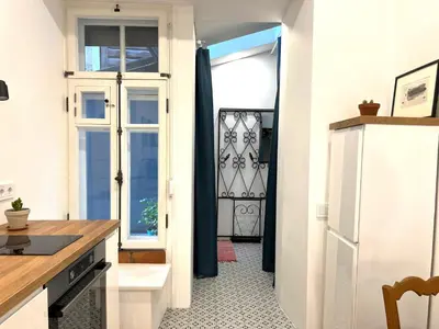 a kitchen with a door open to a kitchen with a floor at Cozy studio in Sv Stepono g. in Vilnius