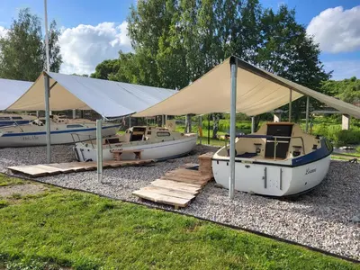a group of boats parked under a tent at Uždubysio baidarės Nakvynė Jachtose (Night on a Yacht) in Ariogala