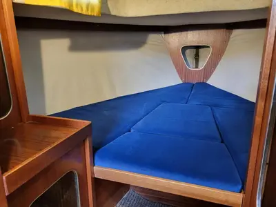 a blue bed in the bottom bunk of a boat at Uždubysio baidarės Nakvynė Jachtose (Night on a Yacht) in Ariogala