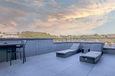 a patio with a table and chairs on a balcony at Apartments in Kaunas city centre with Jacuzzi bath in Kaunas