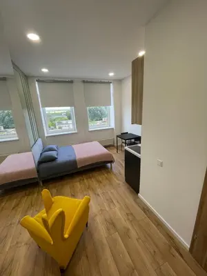 a living room with a couch and a yellow chair at 22 Airport Apartment in Vilnius