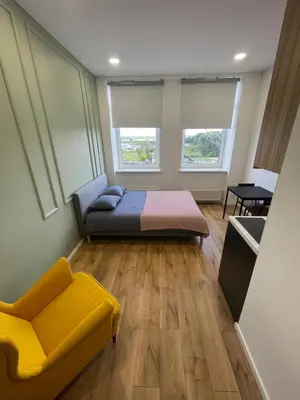 a bedroom with a bed and a couch and two windows at 22 Airport Apartment in Vilnius