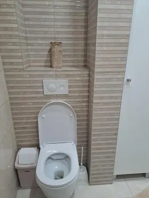 a bathroom with a toilet and a basket on the wall at ZS apartment in Druskininkai