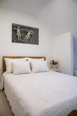 a bedroom with a large bed with white sheets at Gallery Balta Apartments in Kaunas