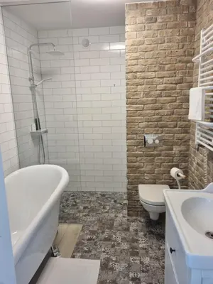 a bathroom with a tub and a toilet and a sink at Gallery Balta Apartments in Kaunas