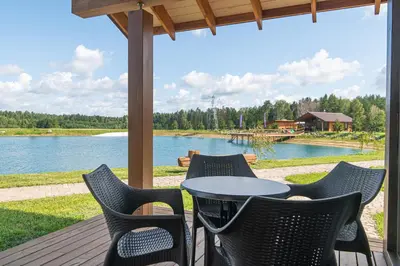 a table and chairs on a deck with a view of a lake at Royal Horse Resort in Balkasodis