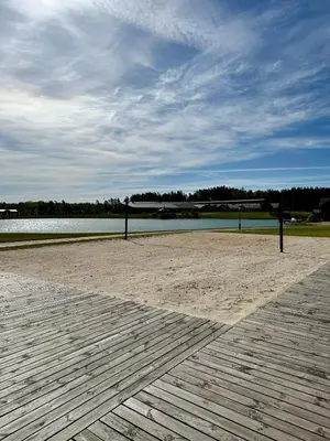 a volley ball net on a beach with a body of water at Royal Horse Resort in Balkasodis
