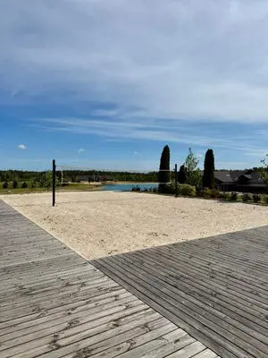 a wooden boardwalk next to a beach with a body of water at Royal Horse Resort in Balkasodis