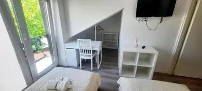 a bedroom with a desk and a table and a window at Fortress Stay in Kaunas