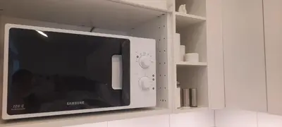 a microwave oven in a white kitchen cabinet at Fortress Stay in Kaunas