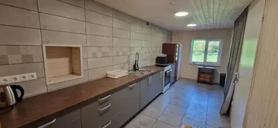 a large kitchen with a sink and a counter at Šušvė in Plinkaigalis