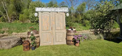 a wooden gate in a yard with potted plants at Šušvė in Plinkaigalis