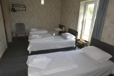 a hotel room with three beds and a window at Šušvė in Plinkaigalis