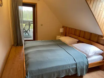 a bedroom with a large bed with a window at Forest springs. Family vacation tennis beach sauna in GratiÅ¡kÄ—s