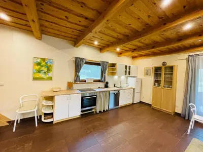 a kitchen with white cabinets and a wooden ceiling at Forest springs. Family vacation tennis beach sauna in GratiÅ¡kÄ—s
