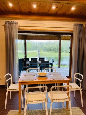 a table and chairs in a room with a large window at Forest springs. Family vacation tennis beach sauna in GratiÅ¡kÄ—s