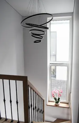 a staircase with a window and a chandelier at Koala rest house in Druskininkai