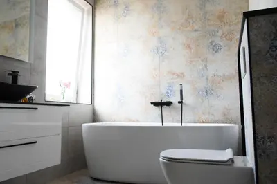 a bathroom with a tub and a toilet and a window at Koala rest house in Druskininkai